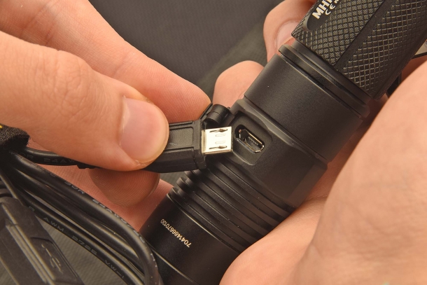 The USB cable port is on the flashlight body side