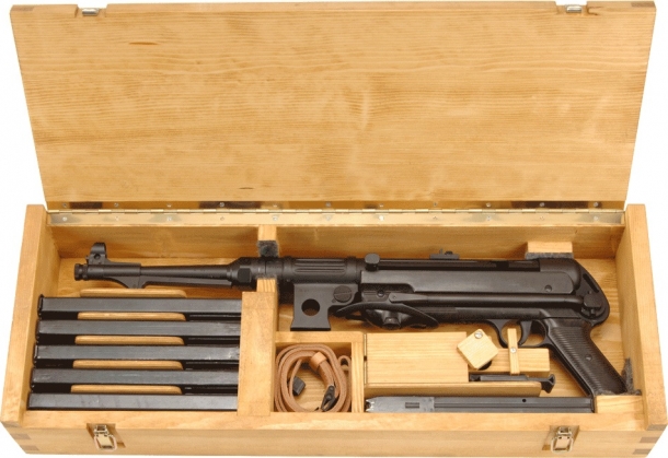 The BD 38's wooden box includes a sling, various magazines, and several other accessories